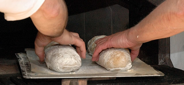 Finished loaves are taken from the Macbiehill bread oven 